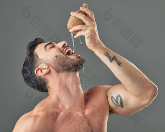<strong>纯天然</strong>水合物工作室拍摄男人。喝椰子水
