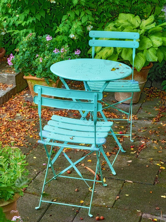 蓝色的院子里金属椅子表格宁静和平郁郁葱葱的私人后院首页萨默斯一天天井家具集座位空宁静的花园新鲜的花植物