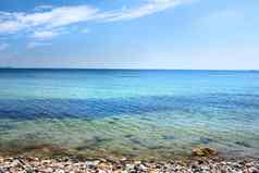 平静海洋波洗石头空海滩海岸帆船巡航地平线风景优美的景观放松夏天假期复制空间海蓝色的天空背景