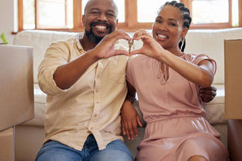 夫妇持有键使心标志手首页肖像微笑快乐非洲美国男人。女人爱坐着休息室首页相机
