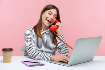 情感年轻的女人坐着工作办公室粉红色的背景