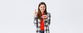 人生活方式假期庆祝活动情绪概念快乐快乐的生日女孩庆祝关闭眼睛交叉手指吹蜡烛使生日蛋糕