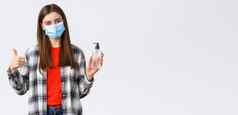 冠状病毒爆发休闲检疫社会距离情绪概念快乐的很高兴年轻的女孩推荐洗手液品牌翘拇指穿医疗面具