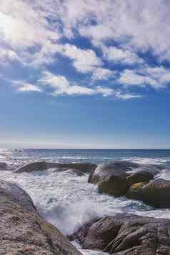 岩石海洋蓝色的多云的天空复制空间风景优美的景观海滩波溅巨石大石头海受欢迎的夏天位置角小镇南非洲