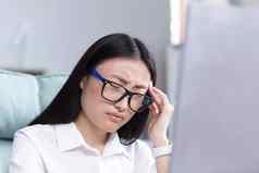 特写镜头照片业务女人累了办公室亚洲女工人持有手头严重的头疼疲劳
