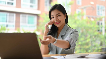 亚洲女企业家谈话细胞电话业务合作伙伴阅读信息移动PC
