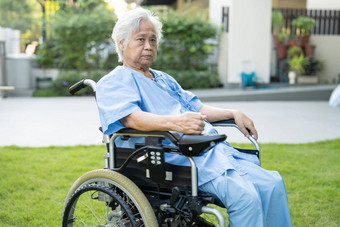 亚洲高级上了年纪的夫人女人病人电轮椅远程控制护理医院病房健康的强大的医疗概念