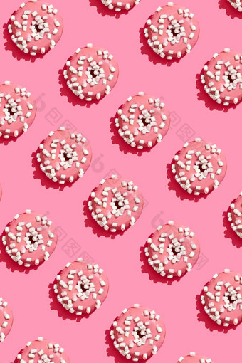 食物设计美味的粉红色的上釉甜甜圈珊瑚粉红色的柔和的背景前视图模式