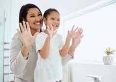 覆盖手指拍摄可爱的女孩洗手妈妈。帮助首页