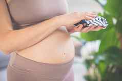 怀孕了女人准备好了交付持有衣服新生儿婴儿怀孕了女人肚子怀孕概念怀孕了肚子关闭