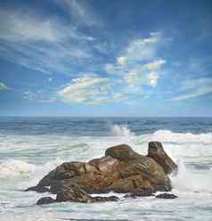 复制空间动荡不安的海粗糙的潮汐波涛汹涌的波强大的风崩溃大巨石海滩多云的蓝色的天空背景岩石海岸西方角南非洲