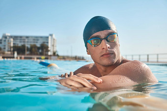 真正的运动员游泳休息玩游戏年轻的男人。游泳奥运池