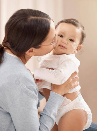 很多吻使快乐婴儿肖像可爱的婴儿女孩举行吻了妈妈。首页