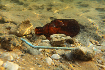啤酒瓶塑料稻草沙子海底水下照片海洋乱扔垃圾污染概念