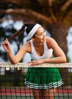 你网球法院运动年轻的女人倾斜网球网