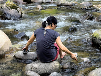 女人休息大河岩石浸泡脚河