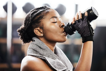 替换失去了汗水有吸引力的年轻的女人站健身房喝水锻炼