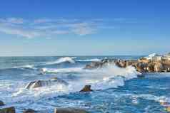 岩石海岸线角省南非洲海洋波崩溃沿海岩石阳光明媚的夏天一天蓝色的清晰的天空风景优美的热带景观海滨西方角