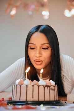 希望祝愿真正的年轻的女人吹蜡烛蛋糕庆祝生日首页
