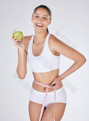 吃健康的看<strong>英寸</strong>消失工作室肖像有吸引力的年轻的女人吃苹果测量<strong>磁带</strong>灰色背景