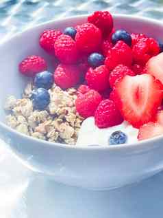 美味的早餐麦片酸奶草莓树莓bluberries花园在户外健康的食物饮食