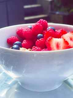 美味的早餐麦片酸奶草莓树莓bluberries花园在户外健康的食物饮食