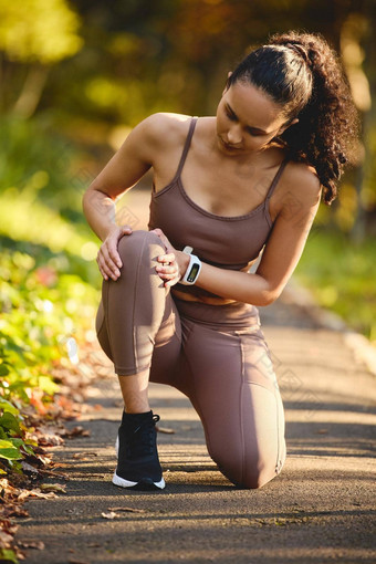 膝盖给问题运动年轻的女人经历膝盖疼痛锻炼在户外