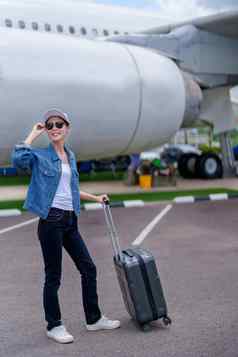 肖像亚洲女人持有手提箱旅行经济类飞机概念假期旅游