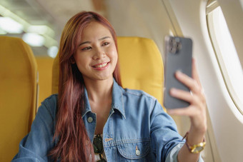 有吸引力的肖像亚洲女人坐着窗口座位<strong>经济类</strong>移动电话机上旅行概念假期放松