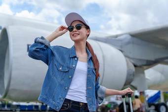 肖像亚洲女人持有手提箱旅行<strong>经济类</strong>飞机概念假期旅游