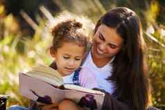 拉伸想象力有吸引力的年轻的女人阅读女儿野餐公园