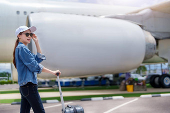 肖像亚洲女人持有手提箱旅行<strong>经济类</strong>飞机概念假期旅游