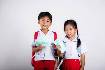 亚洲学生孩子女孩男孩哥哥妹妹穿学生泰国统一的持有保护面具准备好了学校