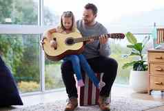 甜蜜的女孩令人惊异的父亲年轻的父亲教学女儿玩吉他首页