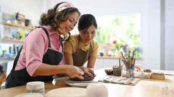 中间岁的女人年轻的女陶艺家使陶瓷碗粘土陶器车间
