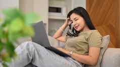 亚洲女自由职业者工作在线冲浪互联网移动PC放松舒适的生活房间