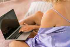 前视图女人的手紫色的睡衣移动PC沙发