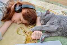 13岁以下的女孩耳机睡觉猫地板上首页
