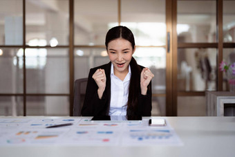 兴奋<strong>年</strong>轻的亚洲业务女人<strong>庆</strong>祝成功的金融项目结果吸引重要的<strong>企业</strong>客户端梦想目标成就