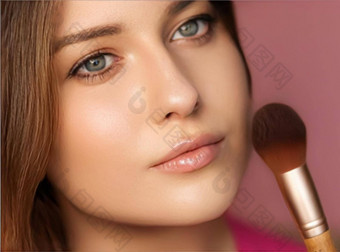 美丽的年轻的女人应用化妆品粉产品化妆竹子刷美化妆护肤品化妆品模型脸肖像粉红色的背景