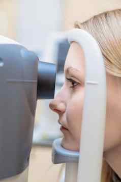 年轻的女孩接待眼科医生检查视力特殊的装置特写镜头