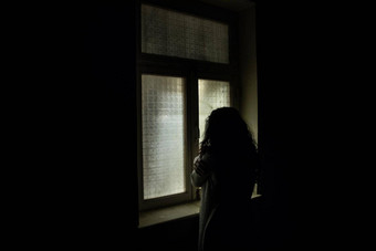 恐怖女人窗口木手持有笼子里可怕的场景万圣节概念模糊轮廓女巫恐怖主题