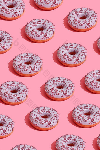 食物设计美味的粉红色的上釉甜甜圈珊瑚粉红色的柔和的背景前视图模式