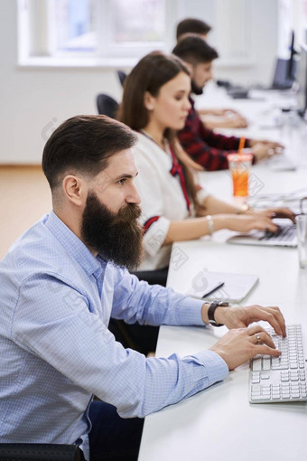 人工作现代办公室集团年轻的有经验的程序员<strong>软件开发</strong>人员坐着桌子工作电脑团队工作