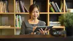 亚洲女员工搜索信息在线数字平板电脑工作有创意的办公室