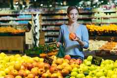 女人选择水果蔬菜计数器超市女家庭主妇购物市场