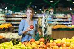 女人选择水果蔬菜计数器超市女家庭主妇购物市场