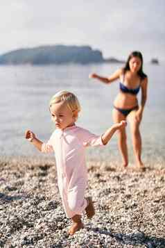 女孩走光着脚卵石海滩