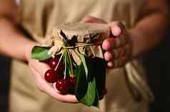 细节家庭主妇持有Jar自制的樱桃浆果小时罐头保存甜蜜的食物