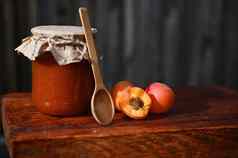 生活Jar小时成熟的即食红色的阳光明媚的杏子木勺子乡村木表面罐头概念